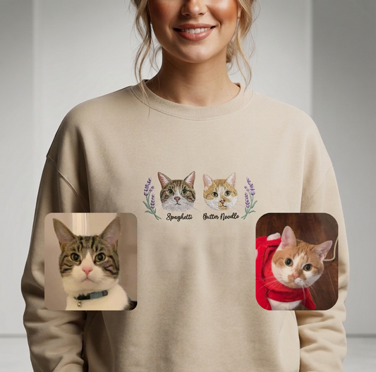 Beige sweatshirt with cat illustrations and text worn by a person