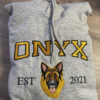 Gray hoodie with embroidered 'ONYX' and '2021' on a wooden surface